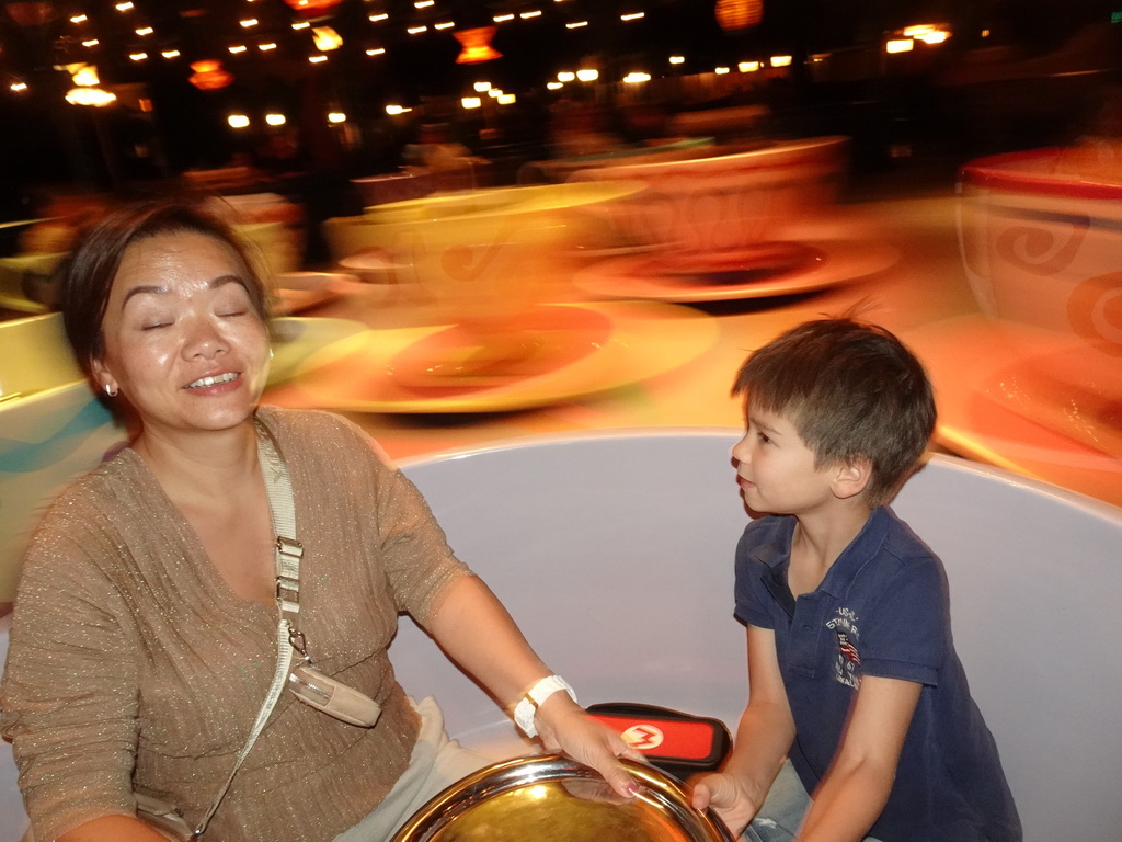 Miaomiao and Max at the Mad Hatter`s Tea Cups attraction at Fantasyland at Disneyland Park, by night