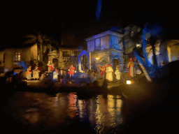 Pirate statues at a well at the Pirates of the Caribbean attraction at Adventureland at Disneyland Park, viewed from our boat, by night