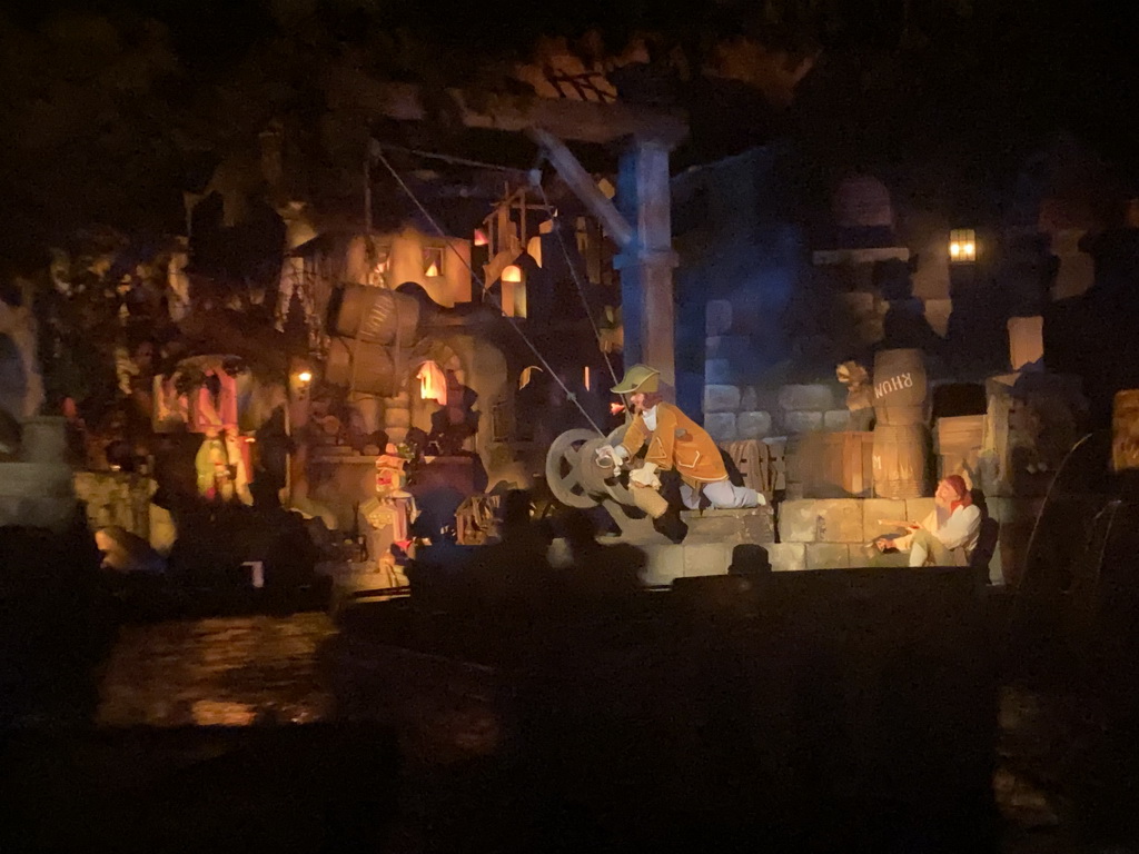 Statues at a harbour at the Pirates of the Caribbean attraction at Adventureland at Disneyland Park, viewed from our boat, by night