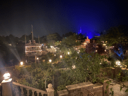 The Thunder Mesa Riverboat Landing attraction and the Silver Sput Steakhouse restaurant at Frontierland and Sleeping Beauty`s Castle at Fantasyland at Disneyland Park, viewed from the staircase to the Phantom Manor attraction at Frontierland, by night