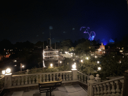 The Thunder Mesa Riverboat Landing attraction and the Silver Sput Steakhouse restaurant at Frontierland and Sleeping Beauty`s Castle at Fantasyland at Disneyland Park, viewed from the staircase to the Phantom Manor attraction at Frontierland, during the Disney D-Light drone show, by night