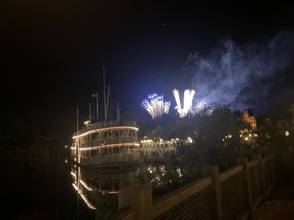 The Thunder Mesa Riverboat Landing attraction at Frontierland and fireworks above Sleeping Beauty`s Castle at Fantasyland at Disneyland Park, during the Disney Illuminations show, by night