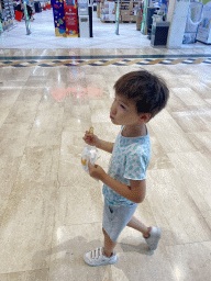 Max eating chicken nuggets at the lower floor of the Centre Commercial Val d`Europe shopping mall at Serris