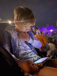 Max playing on the Nintendo Switch at Central Plaza at Disneyland Park, by night