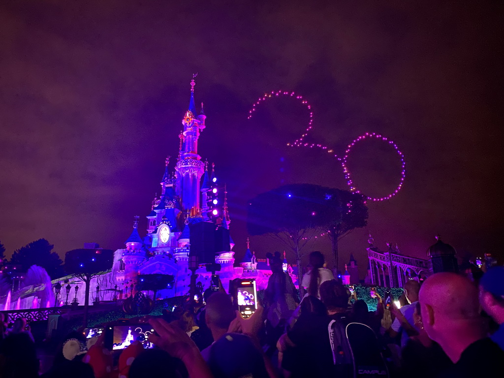 Front of Sleeping Beauty`s Castle at Fantasyland at Disneyland Park, with illuminations and drones during the Disney D-Light drone show, viewed from Central Plaza, by night