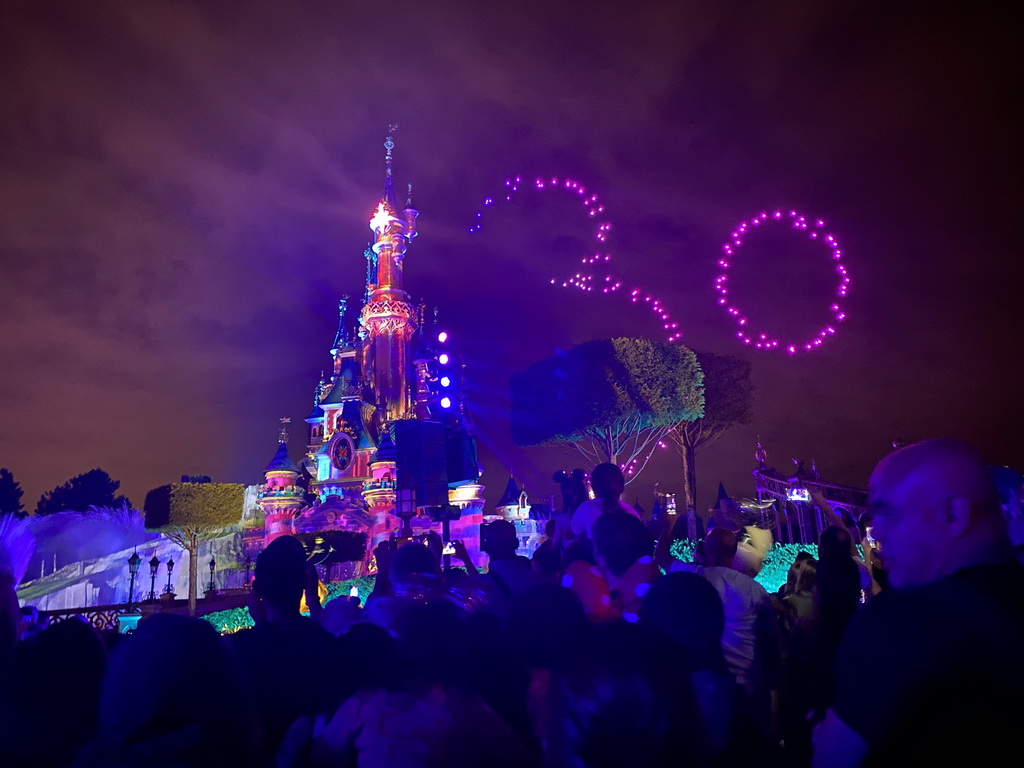 Front of Sleeping Beauty`s Castle at Fantasyland at Disneyland Park, with illuminations and drones during the Disney D-Light drone show, viewed from Central Plaza, by night