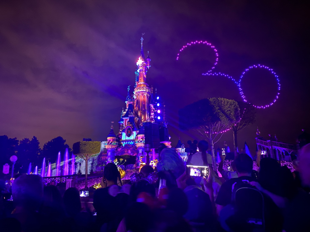 Front of Sleeping Beauty`s Castle at Fantasyland at Disneyland Park, with illuminations and drones during the Disney D-Light drone show, viewed from Central Plaza, by night