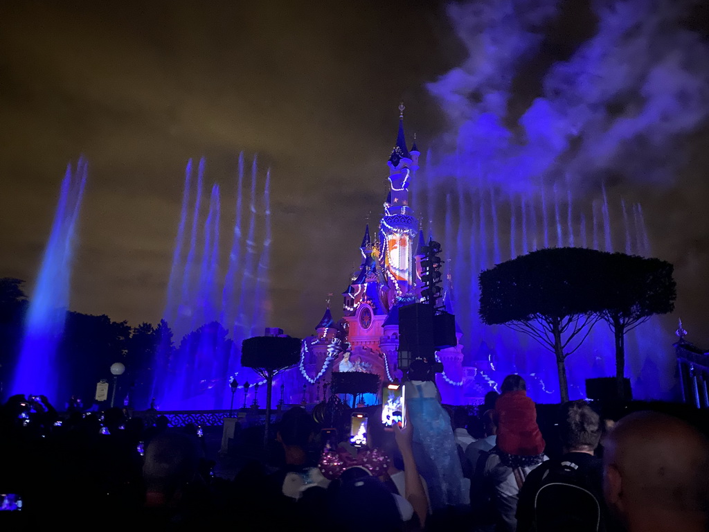 Front of Sleeping Beauty`s Castle at Fantasyland at Disneyland Park, with illuminations, fireworks and fountains during the Disney Illuminations show, viewed from Central Plaza, by night