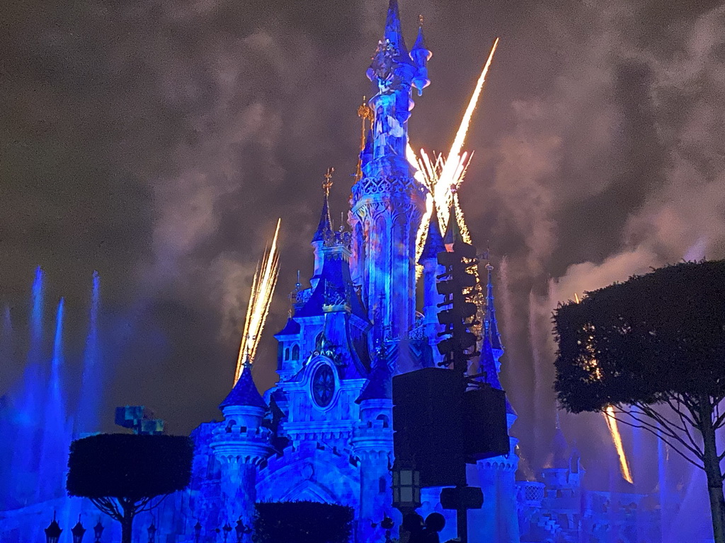 Front of Sleeping Beauty`s Castle at Fantasyland at Disneyland Park, with illuminations, fireworks and fountains during the Disney Illuminations show, viewed from Central Plaza, by night