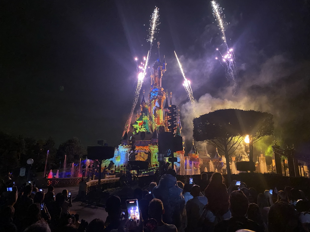 Front of Sleeping Beauty`s Castle at Fantasyland at Disneyland Park, with illuminations, fireworks and fountains during the Disney Illuminations show, viewed from Central Plaza, by night