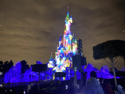 Front of Sleeping Beauty`s Castle at Fantasyland at Disneyland Park, with illuminations and fountains during the Disney Illuminations show, viewed from Central Plaza, by night