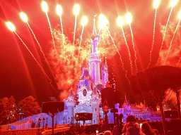 Front of Sleeping Beauty`s Castle at Fantasyland at Disneyland Park, with illuminations and fireworks during the Disney Illuminations show, viewed from Central Plaza, by night