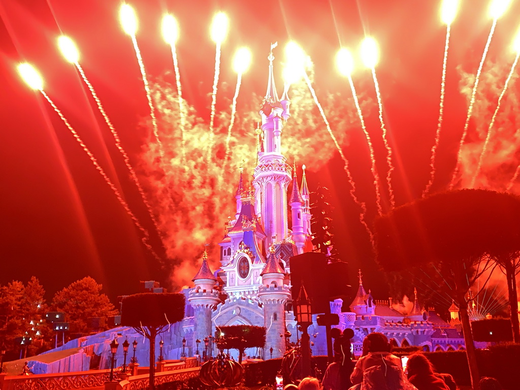 Front of Sleeping Beauty`s Castle at Fantasyland at Disneyland Park, with illuminations and fireworks during the Disney Illuminations show, viewed from Central Plaza, by night