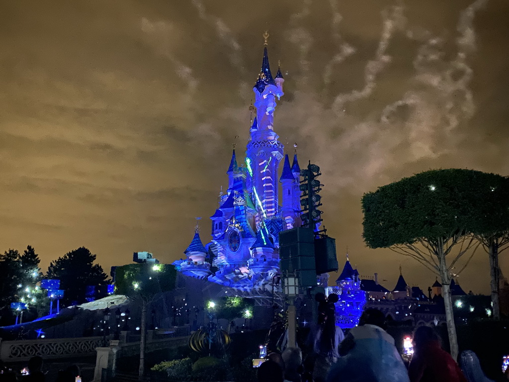 Front of Sleeping Beauty`s Castle at Fantasyland at Disneyland Park, with illuminations during the Disney Illuminations show, viewed from Central Plaza, by night