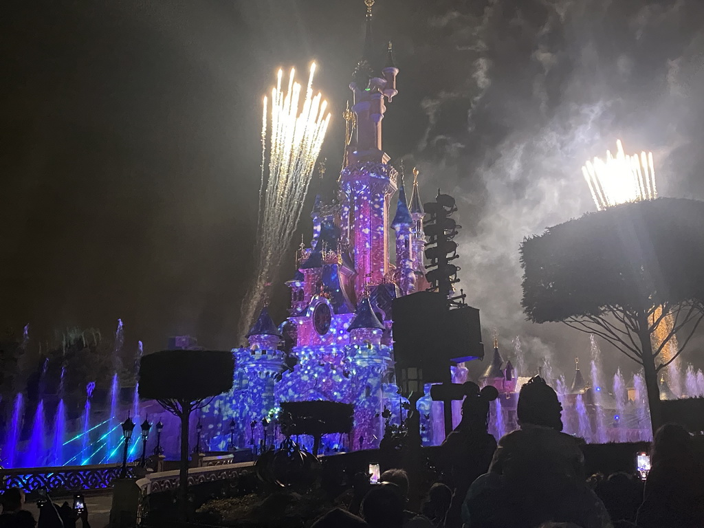 Front of Sleeping Beauty`s Castle at Fantasyland at Disneyland Park, with illuminations, fireworks and fountains during the Disney Illuminations show, viewed from Central Plaza, by night