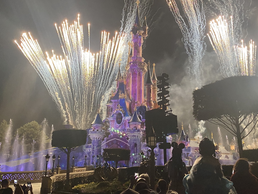 Front of Sleeping Beauty`s Castle at Fantasyland at Disneyland Park, with illuminations, fireworks and fountains during the Disney Illuminations show, viewed from Central Plaza, by night