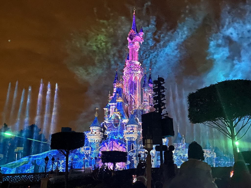 Front of Sleeping Beauty`s Castle at Fantasyland at Disneyland Park, with illuminations, fireworks and fountains during the Disney Illuminations show, viewed from Central Plaza, by night