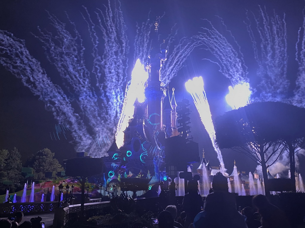 Front of Sleeping Beauty`s Castle at Fantasyland at Disneyland Park, with illuminations, fireworks and fountains during the Disney Illuminations show, viewed from Central Plaza, by night