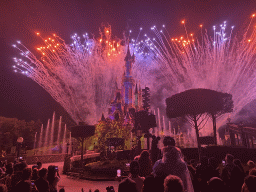 Front of Sleeping Beauty`s Castle at Fantasyland at Disneyland Park, with illuminations, fireworks and fountains during the Disney Illuminations show, viewed from Central Plaza, by night