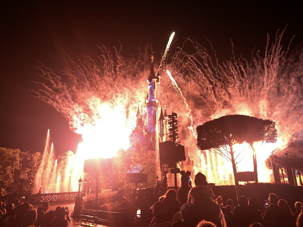 Front of Sleeping Beauty`s Castle at Fantasyland at Disneyland Park, with illuminations, fireworks and fountains during the Disney Illuminations show, viewed from Central Plaza, by night