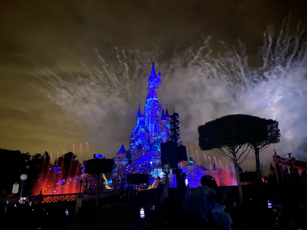 Front of Sleeping Beauty`s Castle at Fantasyland at Disneyland Park, with illuminations, fireworks and fountains during the Disney Illuminations show, viewed from Central Plaza, by night