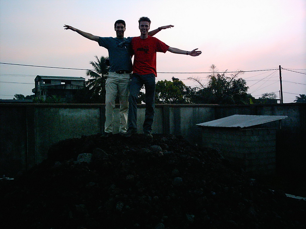 Tim and his friend on top of a pile of stones at a square