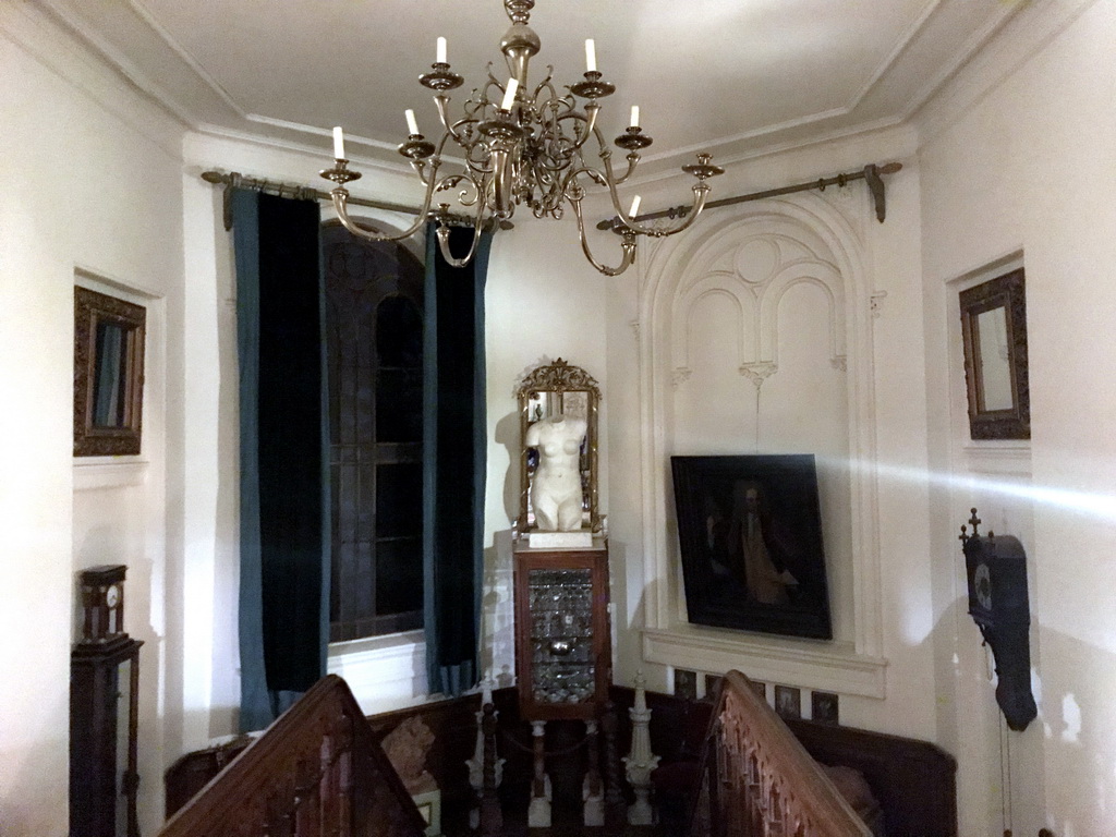 Window, paintings, statues and clocks above the main staircase of Castle Sterkenburg