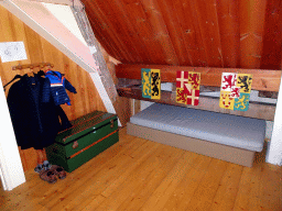 Coat rack, chest, bed and coats of arms in the Kwikstaartkamer room at the upper floor of Castle Sterkenburg