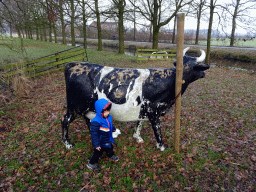 Max with a statue of a cow in the garden of Castle Sterkenburg