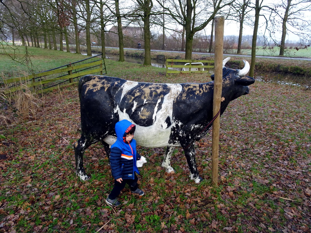 Max with a statue of a cow in the garden of Castle Sterkenburg