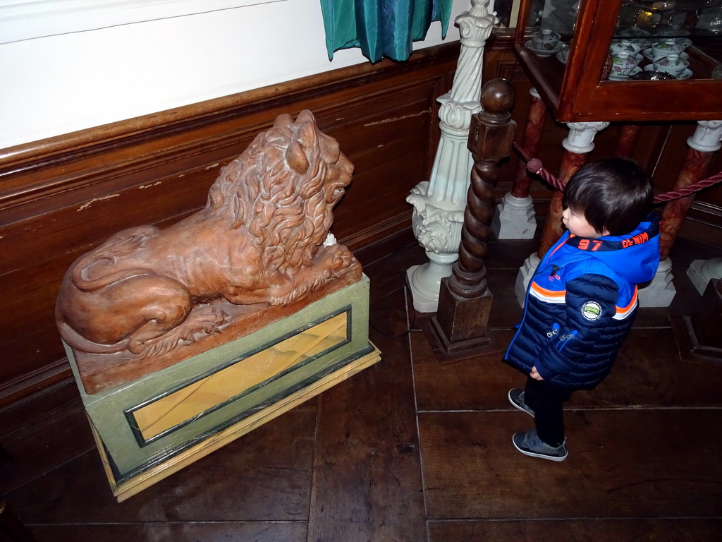 Max with a statue of a Lion in a hallway at the ground floor of Castle Sterkenburg