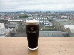 Pint of Guinness beer at the top floor of the Guinness Storehouse, with a view on the Trinity College Dublin and the city center