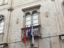 Window and flags at the facade of a building at the Gunduliceva Poljana market square