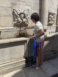 Miaomiao filling a bottle with water at the Large Onofrio Fountain at the Poljana Paska Milicevica street