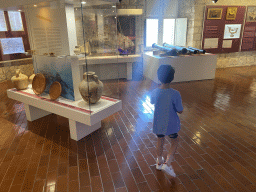 Max with vases, plates, a scale model of a ship and cannons at the lower floor of the Maritime Museum