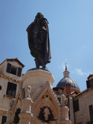Statue of Ivan Gundulic at the Gunduliceva Poljana market square and the dome of the Dubrovnik Cathedral