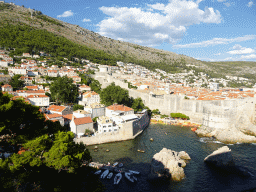 The Old Town with the Tvrdava Minceta fortress, the Pile Gate, the western city walls and the Tvrdava Bokar fortress, Kolorina Bay and kayaks at Bokar Beach, and the pier and boats at the Dubrovnik West Harbour, viewed from the entrance to Fort Lovrijenac