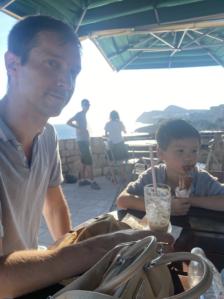 Tim having an ice coffee and Max having an ice cream at the terrace of the Caffe on the Wall restaurant at the top of the Kula sv. Petra fortress, with a view on Fort Lovrijenac and the Velika Petka Hill