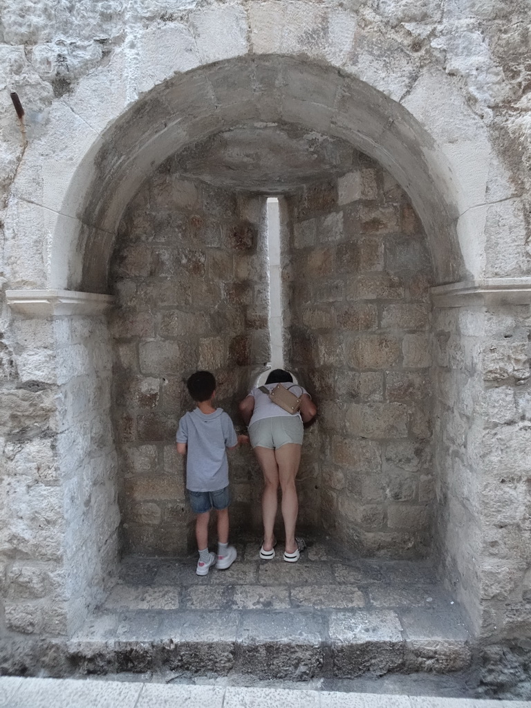 Miaomiao looking through a window and Max at the Ulica Svetog Dominika street