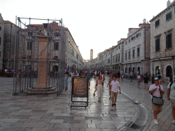 The east side of the Stradun street with Orlando`s Column, under renovation, and the tower of the Franciscan Church