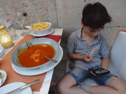 Max eating soup and fries at the terrace of the Konoba Saint Blaise restaurant at the Zeljarica Ulica street