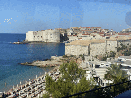 The Plaa Banje Beach, the Lazareti Creative Hub of Dubrovnik and the Old Town with the Porporela Pier, the Tvrdava Svetog Ivana fortress, the Dubrovnik Cathedral and the Bell Tower, viewed from the tour bus to Perast