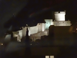 The northwestern city walls with the Tvrdava Minceta fortress, viewed from the tour bus from Perast on the Ulica Maria Perica street, by night