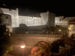The western city walls with the Pile Gate, the Kula Puncjela fortress and the Tvrdava Bokar fortress, viewed from the tour bus from Perast on the Ulica Iza Grada street, by night