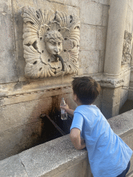 Max getting water at the Small Lionhead Fountain at the Gunduliceva Poljana market square