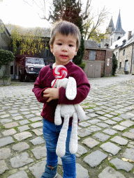 Max with a lolly at the Rue des Récollets street, with a view on the towers of the Église Saint-Nicolas church and the Durbuy Castle