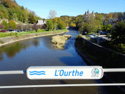 Ourthe river, with sign, and the Durbuy Castle, viewed from the pedestrian bridge at the west side of town