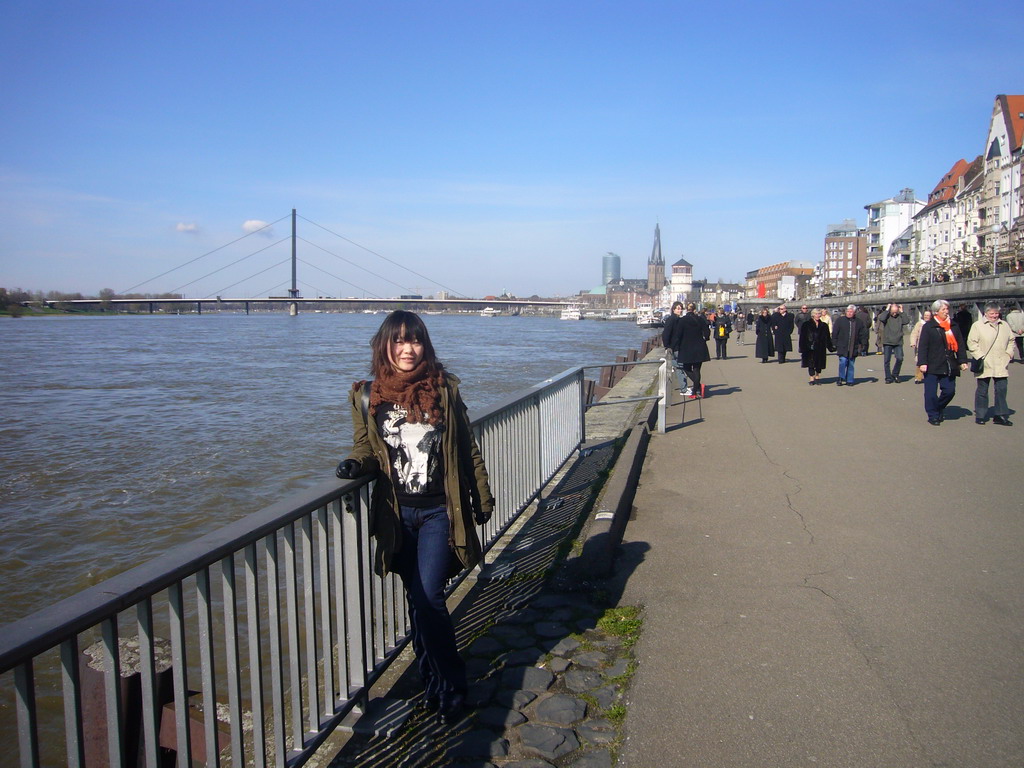 Miaomiao at the Rhine shore, with the Oberkasseler Brücke bridge, the Old Castle Tower and the Lambertuskirche church