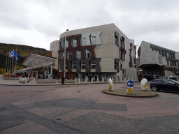Right front of the Scottish Parliament Building at the crossing of the Horse Wynd and the Royal Mile, and Holyrood Park with the Salisbury Crags
