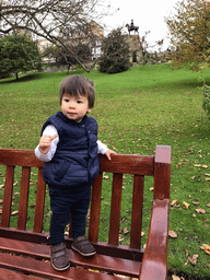 Max standing on a bench at the Princes Street Gardens, with a view on the Royal Scots Greys Memorial